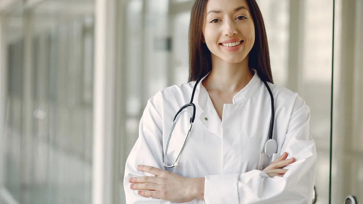 Healthcare student in scrubs studying with a textbook