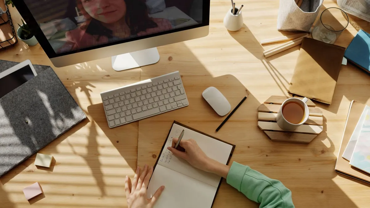 Student studying at a desk with notes and a computer