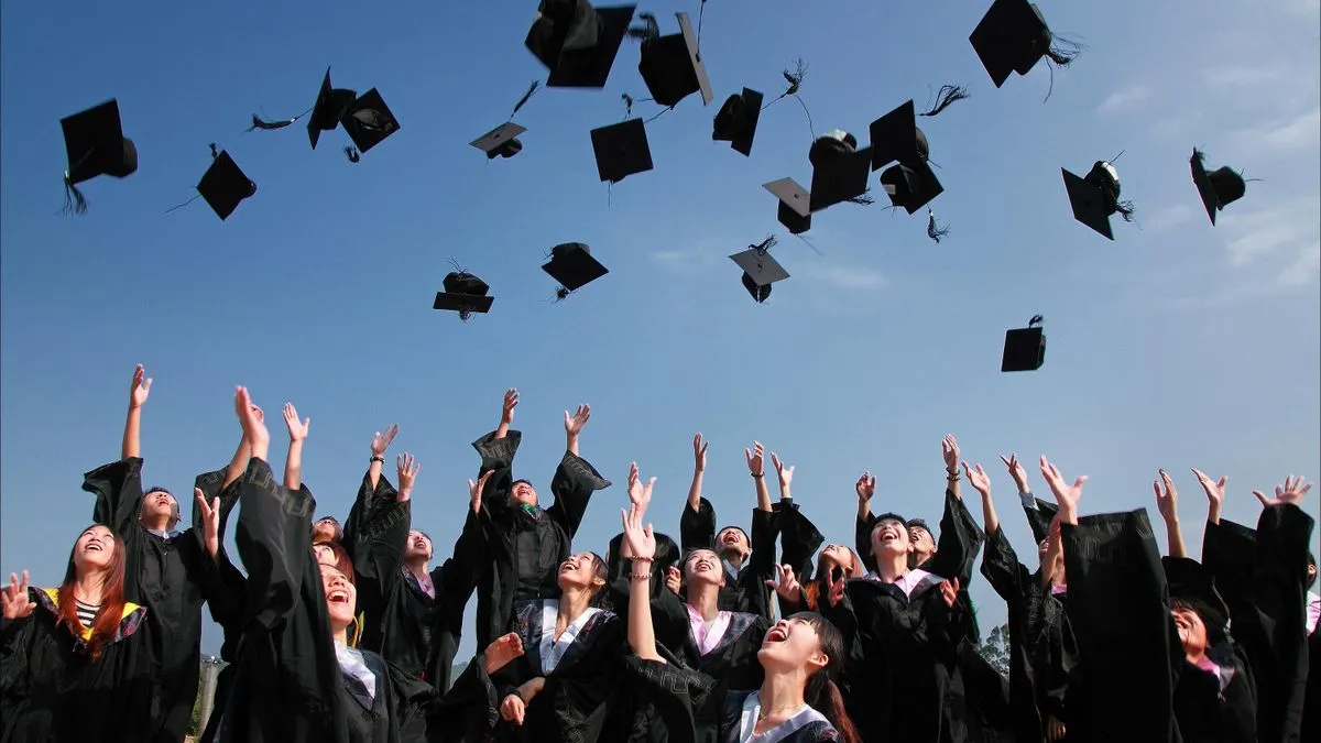 Graduate celebrating with a cap and gown at a university campus